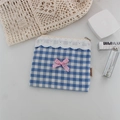 Dettaglio di pochette a quadri blu con bordo in pizzo bianco e fiocco rosa - Quadri Grandi Blu