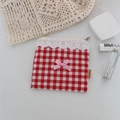 Dettaglio borsa trucco a scacchi rossi con bordo in pizzo e fiocco rosa decorativo - Grandi Quadretti Rossi