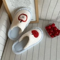 Close-up of plush apple slippers with red embroidery on soft white faux fur material - 36-37 / Blue