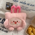 Detail shot of a soft pink plush cartoon rabbit bag with long ears and cute face embroidery - Without Liner / Blush Rabbit