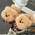 Dettaglio di guanti di peluche orsetto marrone su un manubrio di bicicletta - Orso bruno