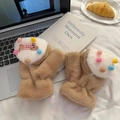 Close-up of plush brown convertible gloves with colorful pom-poms and bear embroidery - Brown