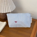 Close-up of blue striped travel pouch with red bow embroidery on a wooden surface - Pink Striped (02) / Small