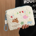 Detail van de witte gewatteerde toilettas met harttextuur en puppy-borduurwerk - Geborduurde Hond Clutch Bag (Met Koord)