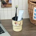 Close-up of cute cartoon dog printed toothbrush cup with toothpaste on a wooden table - Beige Star Dog