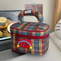 Detailansicht der bunten Karo-Kosmetiktasche mit rotem Reißverschluss und Plüschpuppe - Retro Rotes Karo + Apfelbrosche