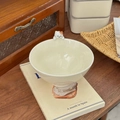 Detail of a creamy ceramic bowl featuring a 3D cute sleeping cat on the rim - Cat Beige
