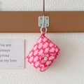 Nahaufnahme der rosa Stoffbörse mit roten Schleifenmustern und Harz-Knopfverschluss - Rosa Schleife