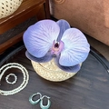Detail of woven bamboo jewelry box with purple orchid and elegant pearl accessories - Purple