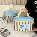 Close-up of a striped dog pattern makeup bag with a yellow top handle and zip closure - Small / Blue-Brown Stripe