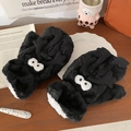 Detail of plush cartoon soot sprite mittens with warm fleece lining on a wooden desk - Soot Sprite Style / Black