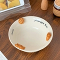 Ceramic bowl featuring a 3D croissant relief and printed text on a wooden table - 6.5 Inch Yogurt Bowl