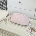 Close-up of pink Jolly cosmetic bag with zipper on a white suitcase in a bedroom - Pink