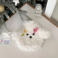 Close-up of white plush teddy dog hot water bottle cover with red bow and festive decor - White