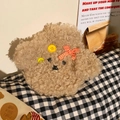 Detail showing plush beige puppy hot water bottle with soft curly fur and orange bow - Beige