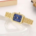 Dettaglio di un orologio rettangolare dorato con quadrante blu su vassoio di porcellana - Blu
