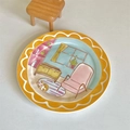 Dettaglio del piatto tondo in ceramica con illustrazione di un soggiorno a cartoni animati - Scena con Bordo Giallo