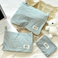 Set di tre organizer in cotone verde menta sul letto con laptop in ambiente lifestyle - Piccolo (18*14cm) / Blu Grigio