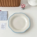 Detail of vintage ceramic plate with blue polka dots and embossed lace edges on a set table - Light Blue