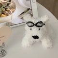Dettaglio portachiavi cane di peluche bianco con occhiali da pilota su scrivania - Cane Con Occhiali Neri
