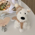 Dettaglio di un cane Westie di peluche bianco con cappello e sciarpa di maglia - Cane Con Cappello E Sciarpa In Maglia Cachi