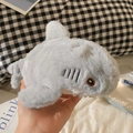 Close-up of small grey plush shark pencil case with soft texture held in hand - Shark