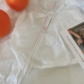 Detail of transparent glass straw with pink bow design and text in aesthetic setting - Bow