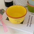 Detailed view of yellow ceramic puppy bowl with orange rim and cute cartoon illustration - Yellow
