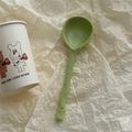 Nahaufnahme eines grünen Keramiklöffels mit langem Stiel und praktischem Aufhängeloch - Matcha-Grün