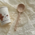 Detail of cream ceramic spoon featuring anti-slip handle with a convenient hanging hole - Milk Coffee