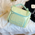 Détail de la trousse de maquillage vert menthe avec broderie et anse à ruban bleu - Grand / Vert