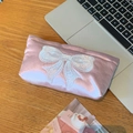 Dettaglio della trousse in seta rosa con ricamo a fiocco bianco e finitura satinata - Medio (17*4*11cm)