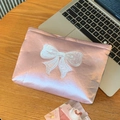 Dettaglio della trousse in raso rosa con fiocco bianco ricamato su scrivania in legno - Grande (21*4*16cm)