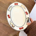 Detail eines ovalen Keramiktellers mit Cartoon-Katze und Kirschmuster im japanischen Stil - Tomatenkatze
