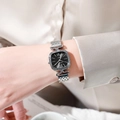 Detail of elegant silver mesh strap and square black dial watch on a female wrist - Silver Black Dial