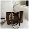 Détail d'un sac cabas marron avec surpiqûres blanches et foulard décoratif sur canapé - Brun Foncé