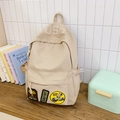Beige canvas backpack with USA embossed lettering and retro patches in minimalist setting - No Pendant / Khaki