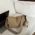 Bolso bandolera minimalista de nailon caqui con monedero redondo en sofá blanco - Caqui