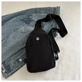 Detail of black nylon crossbody bag with metal M logo on denim jacket surface - Black