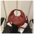 Dettaglio borsa a mano rossa intrecciata con fibbia dorata e manico elegante - Rosso