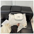 Close-up of a white PU leather shoulder bag featuring a silver metal bow detail - White
