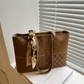 Sac fourre-tout marron en patchwork géométrique avec foulard décoratif sur livres blancs - Fauve