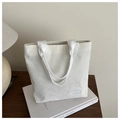Primer plano del bolso tote de pana blanca con finas rayas y etiqueta de marca - Blanco