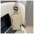 Detail view of light khaki nylon chest bag with zippers beside a laptop on a chair - Fashion Design (9496-F) / Khaki