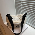 Sac bandoulière demi-lune en nylon blanc avec sangle réglable posé sur un livre - Blanc