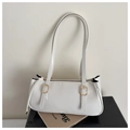 Detail view of white faux leather texture and gold adjustable buckles on shoulder bag - White