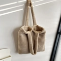 Detail of soft beige plush tote bag with lamb-like texture hanging on a wooden hook - Khaki