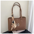 Detailansicht einer braunen Shopper-Tasche mit Kontrastnähten und elegantem Seidenschal - Hellbraun