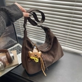 Borsa hobo marrone scuro opaca con ciondolo a orsetto su una scrivania moderna - Con Ciondolo / Marrone