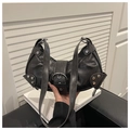 Detalle del bolso de moto punk negro con textura de cuero vintage y tachuelas plateadas - Negro